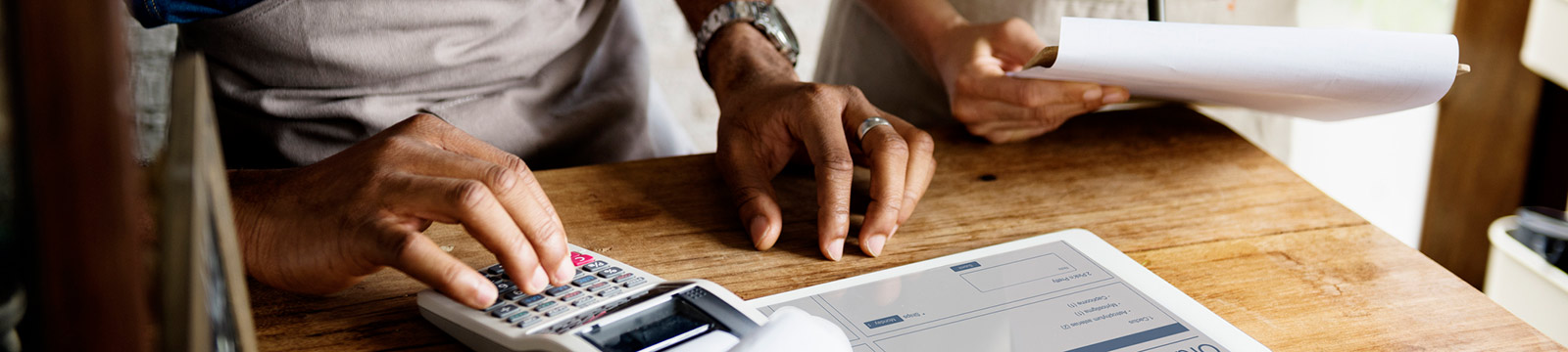 Man using adding machine and iPad.