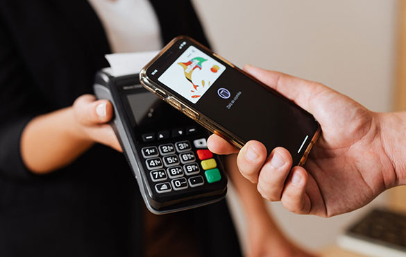 Man holding phone up to credit card reader paying with mobile wallet.